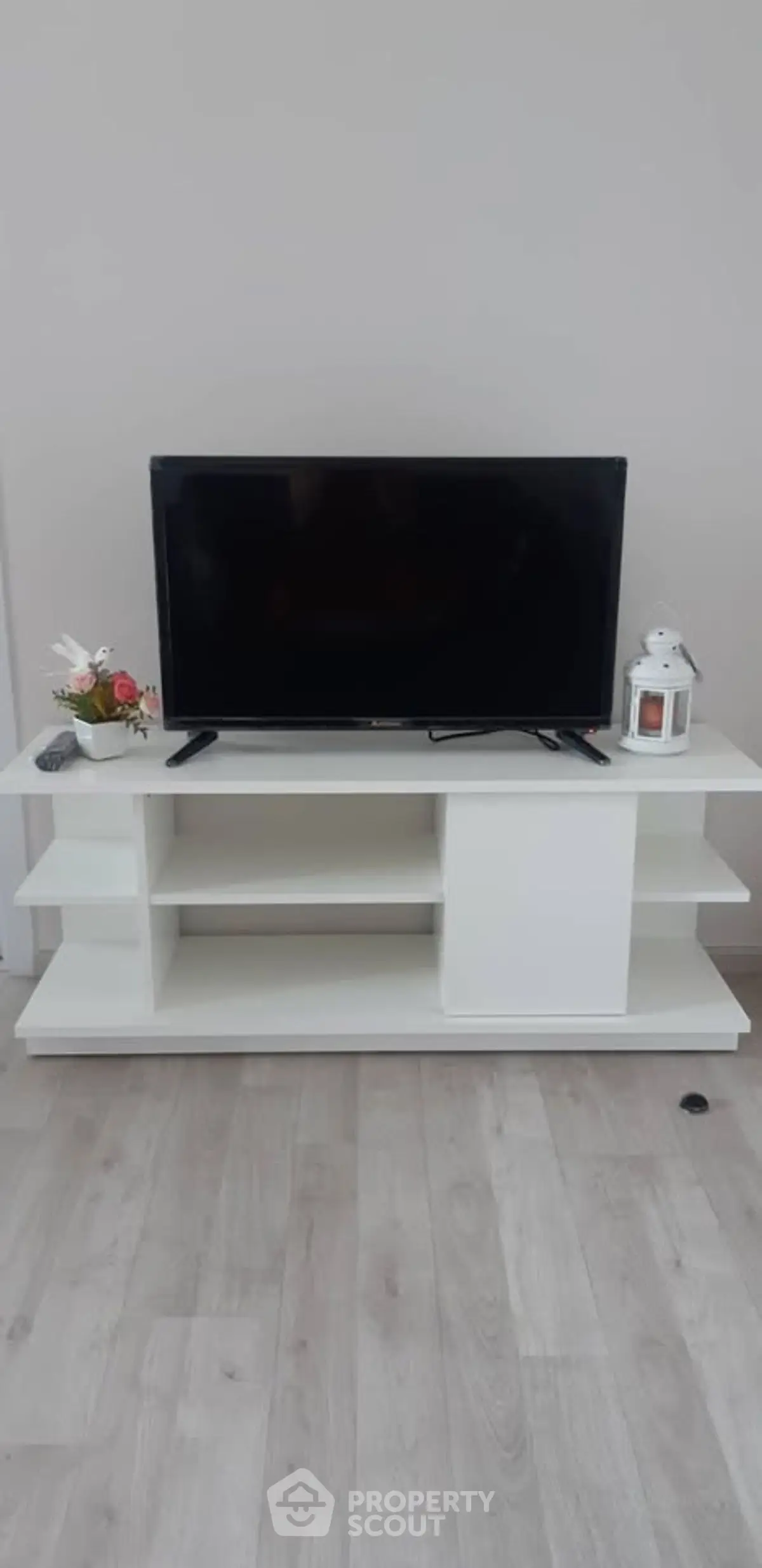 Modern living room with sleek TV stand and flat-screen TV, perfect for entertainment setup.