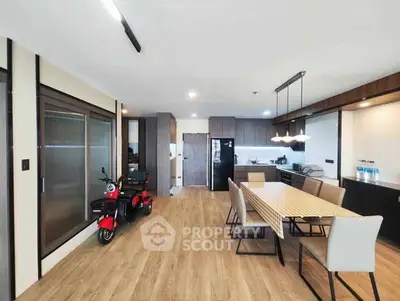 Spacious modern kitchen with dining area and sleek wooden flooring.