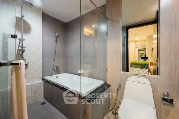 Modern bathroom with glass shower and bathtub in luxury apartment.