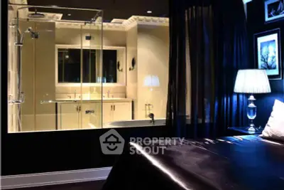 Luxurious bedroom with glass-enclosed bathroom and elegant lighting