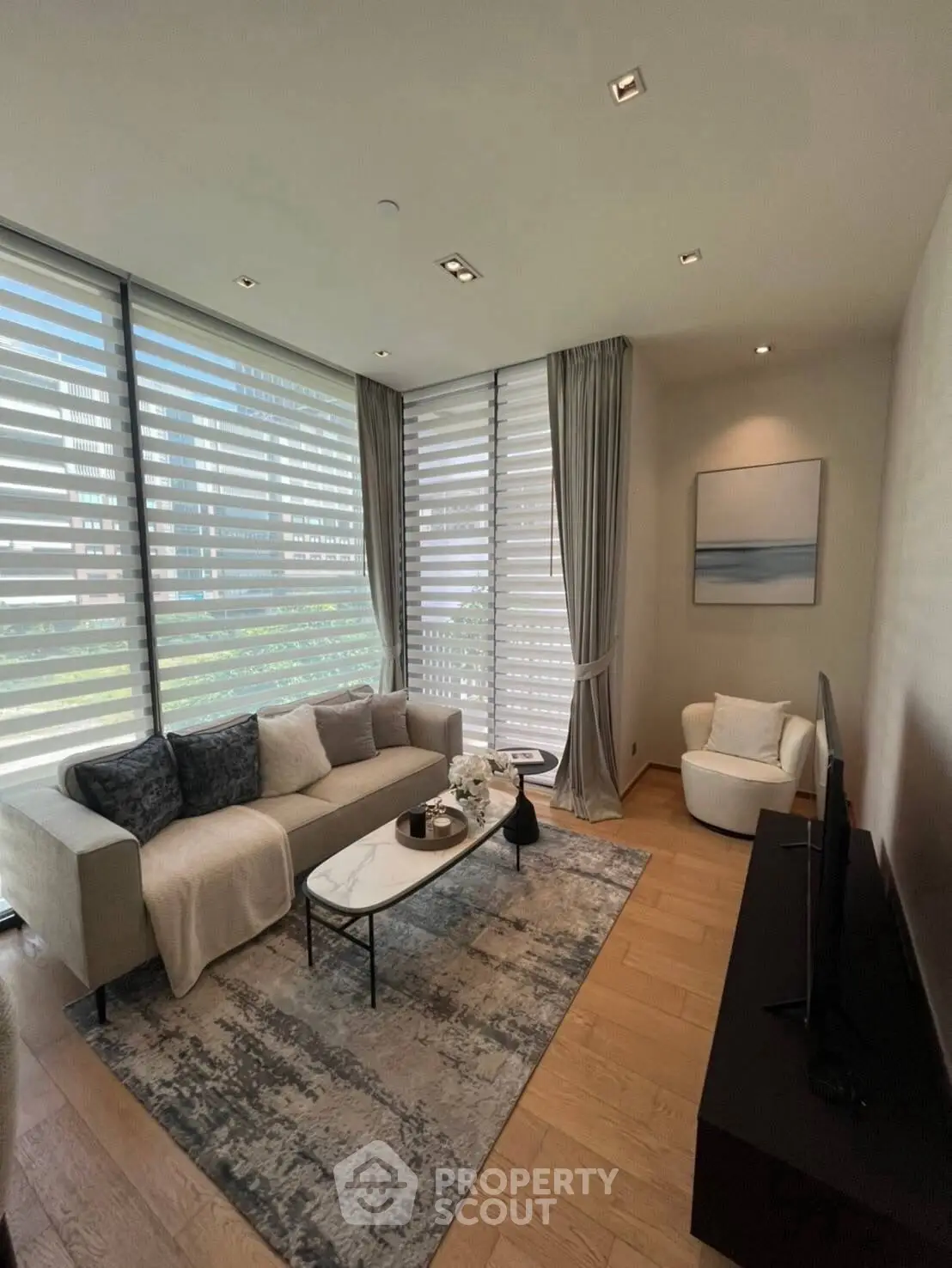 Modern living room with stylish decor and large windows offering natural light.