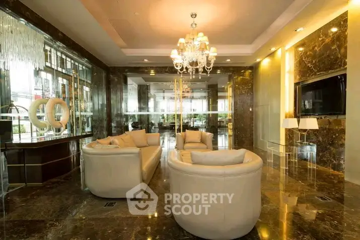 Luxurious living room with elegant chandelier and marble flooring in upscale property.