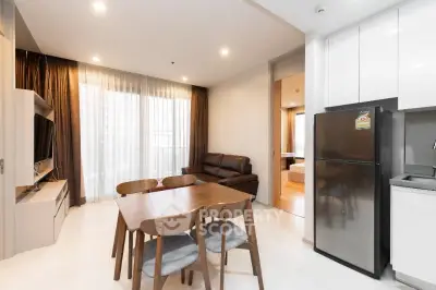 Modern open-plan living room with dining area and kitchen in a stylish apartment.