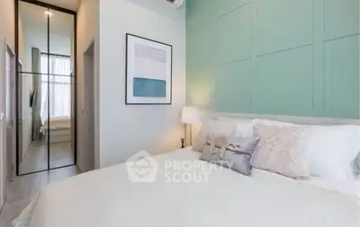 Modern bedroom with stylish decor and mirrored closet doors in a cozy apartment.