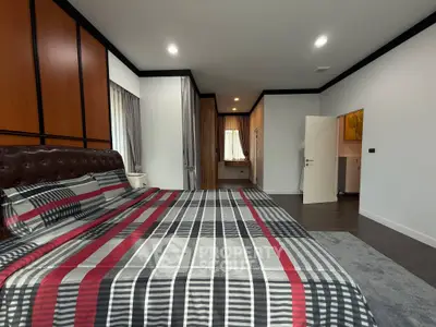 Spacious modern bedroom with stylish decor and ample natural light.