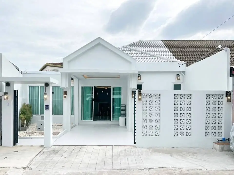 Charming modern white house with unique architectural design and spacious driveway.