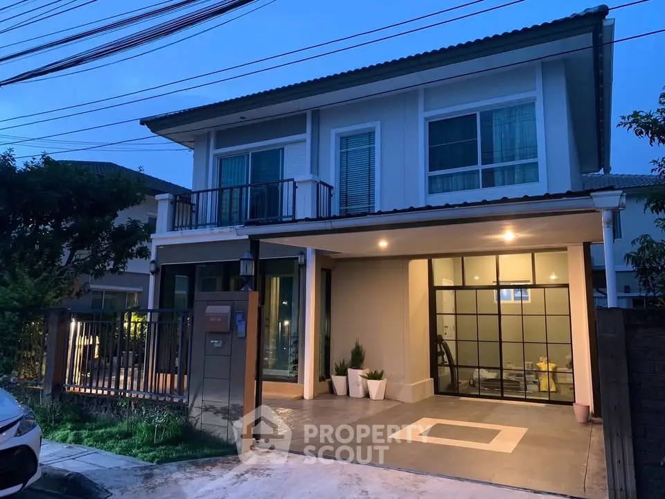 Modern two-story house with large windows and a spacious driveway, perfect for family living.