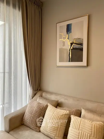 Elegant living room with modern art and plush cushions on a beige sofa, perfect for relaxation.