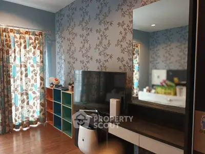 Charming living room with floral wallpaper and modern TV setup