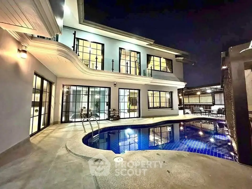 Luxurious modern home with stunning night-lit pool and elegant architecture.
