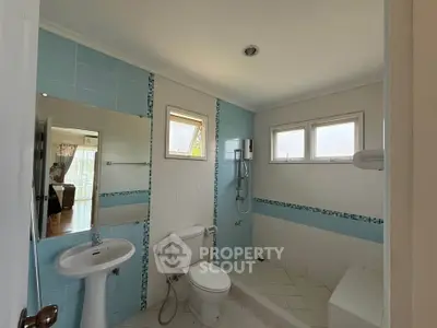 Spacious bathroom with modern fixtures and natural light, featuring a shower and large windows.