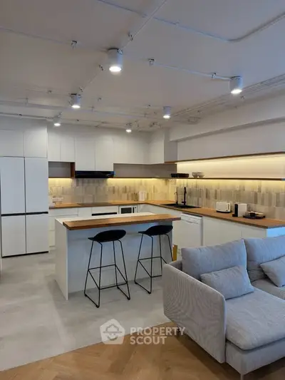 Modern open-layout kitchen with sleek design and cozy living area