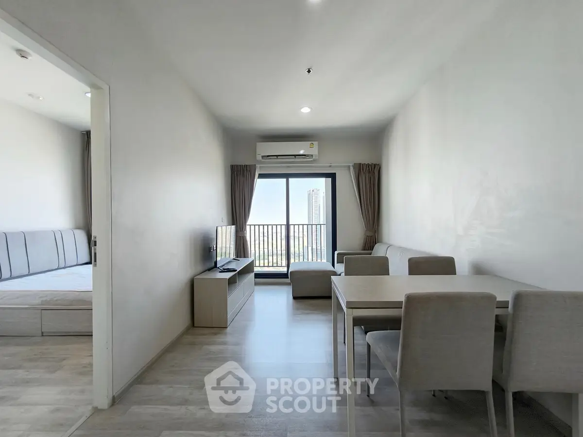 Modern living room with dining area and balcony view in a stylish apartment.