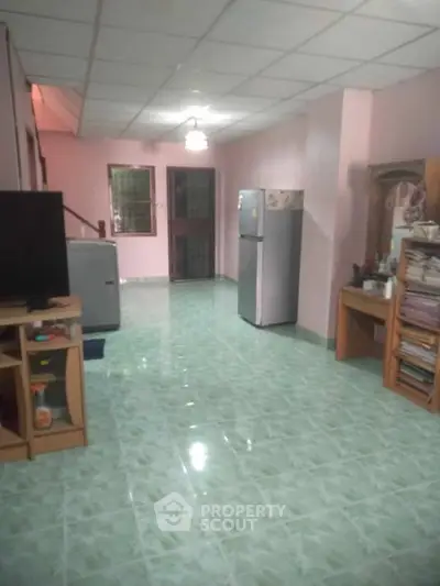 Spacious living area with tiled flooring and modern appliances, perfect for comfortable living.