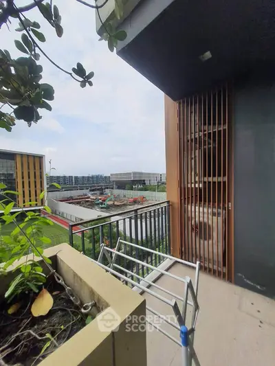 Modern balcony with urban view and greenery, perfect for relaxation and city living.