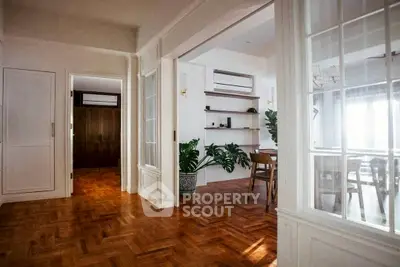 Spacious open-layout living area with elegant parquet flooring and abundant natural light.