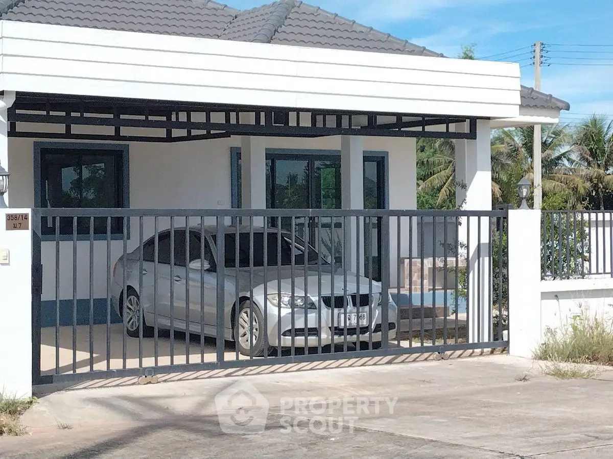 Modern single-story home with gated parking and sleek exterior design.