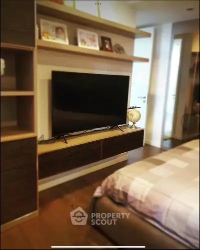 Modern bedroom with wall-mounted TV and stylish shelving