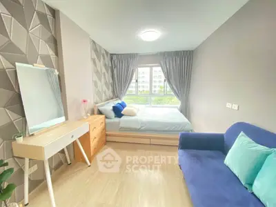 Modern bedroom with stylish decor, featuring a cozy bed, elegant dresser, and a comfortable blue sofa.