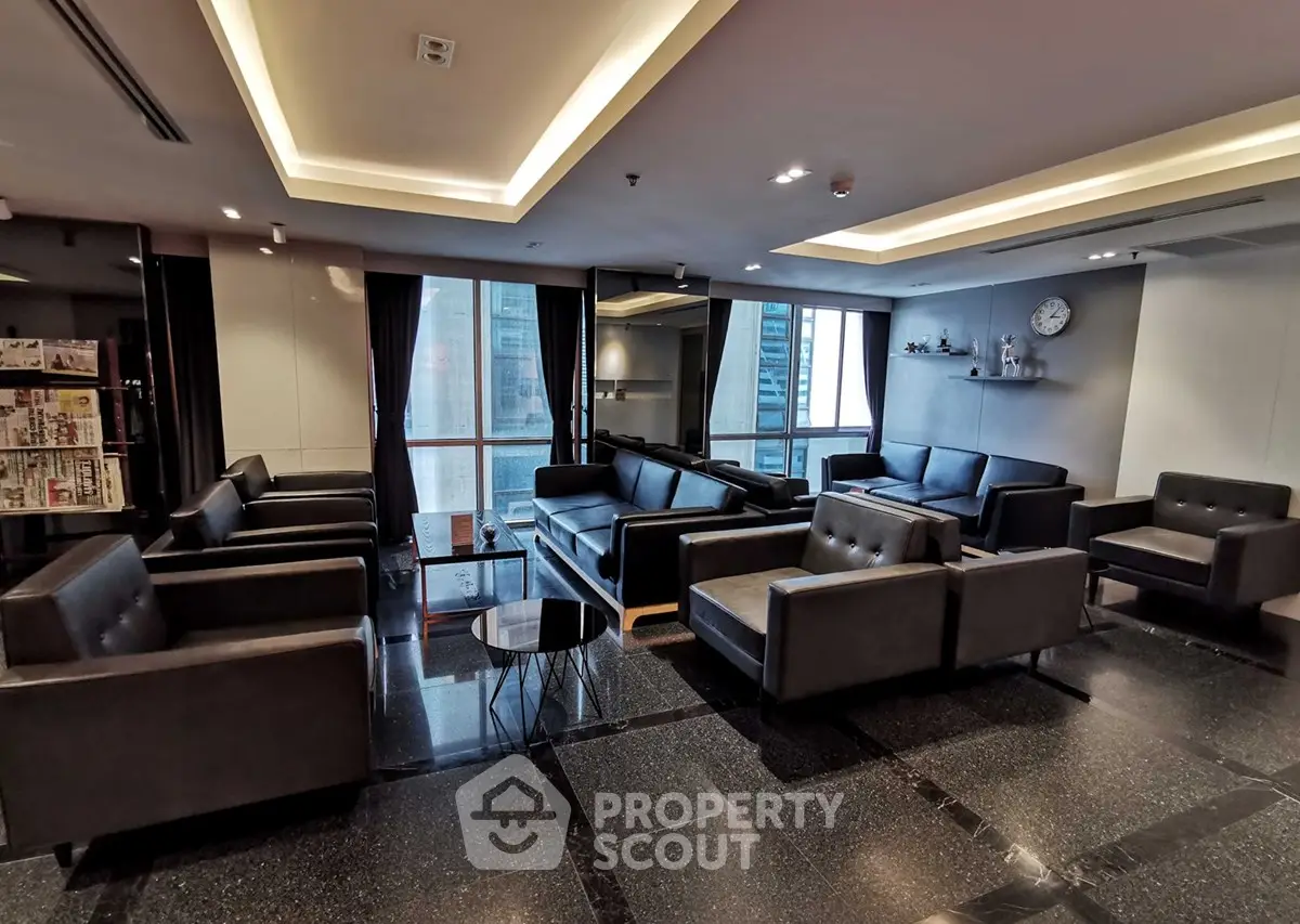 Luxurious modern living room with sleek black leather sofas and city view, perfect for relaxation and entertainment.