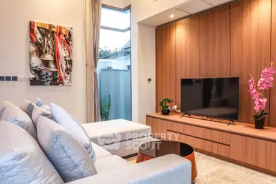 Modern living room with stylish decor and large TV unit, featuring cozy seating and elegant wooden paneling.