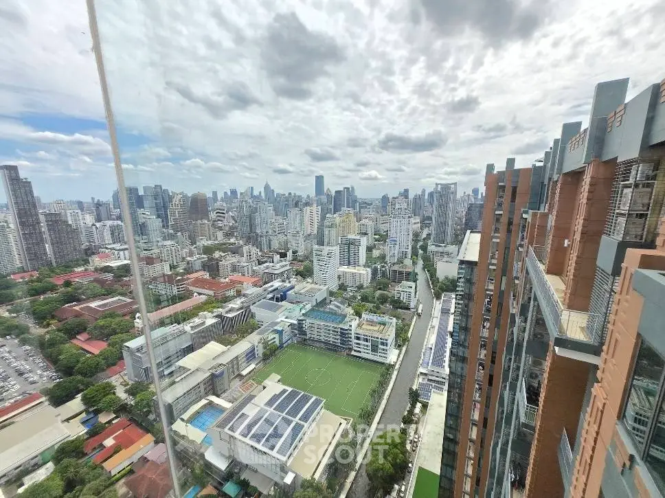 Stunning cityscape view from high-rise building showcasing urban skyline and lush greenery.
