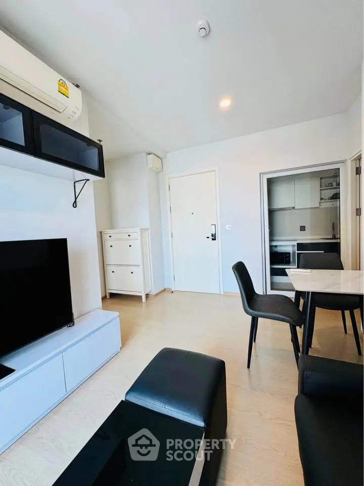 Modern living room with sleek furniture and open kitchen layout in a stylish apartment.