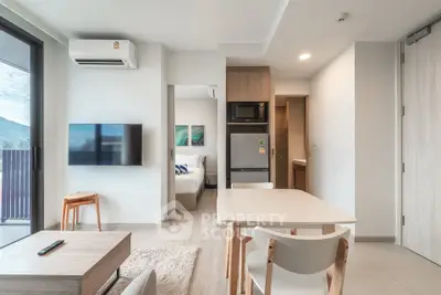 Modern open-plan living room with kitchen and bedroom view in stylish apartment