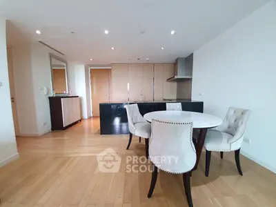 Spacious modern dining area with elegant chairs and wooden flooring in a stylish apartment.