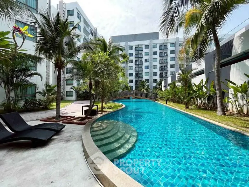 Luxurious apartment complex with stunning pool and lush palm trees, perfect for relaxation and leisure.