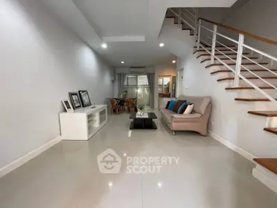 Spacious modern living room with sleek staircase and cozy seating area