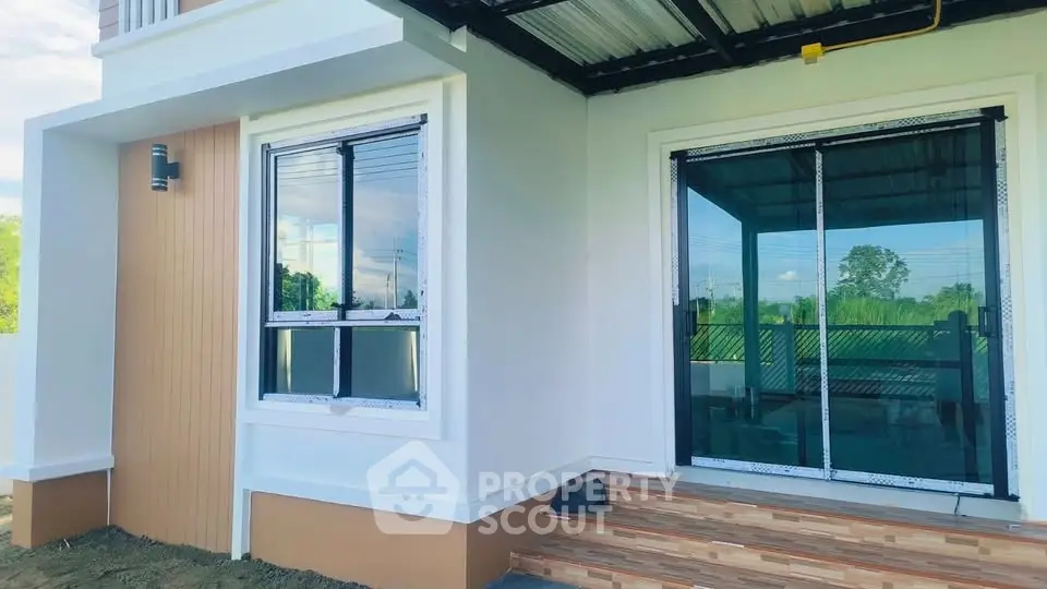 Modern house exterior with large windows and sliding glass door