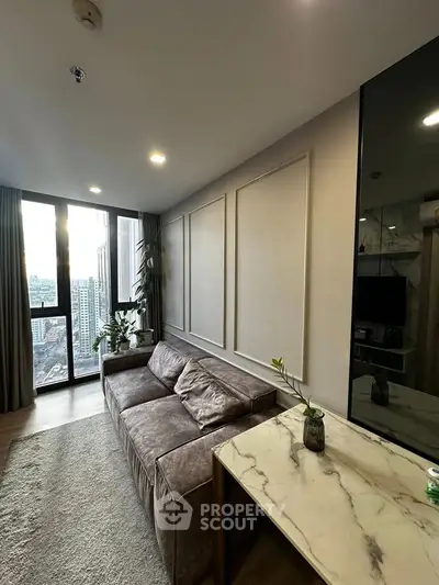 Modern living room with city view, elegant decor, and cozy seating area.