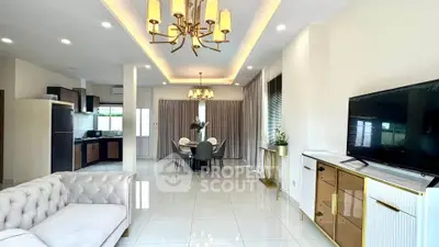 Spacious open-plan living and dining area with modern kitchen and elegant lighting.