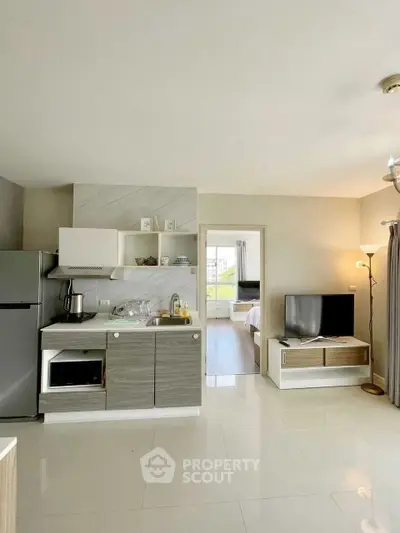 Modern open-layout kitchen with sleek appliances and cozy living area, perfect for urban living.