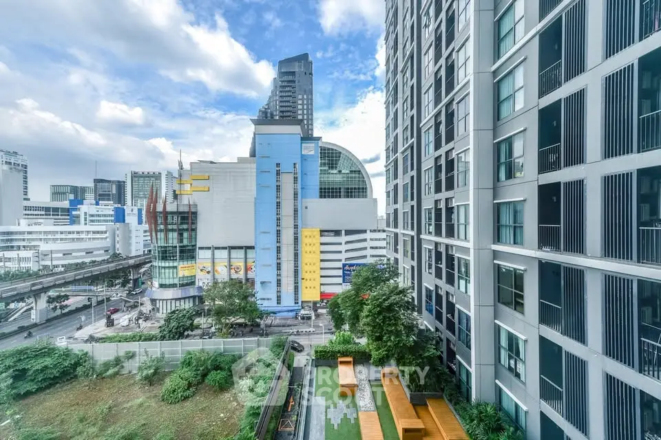 Stunning urban view from modern high-rise apartment with lush garden terrace.