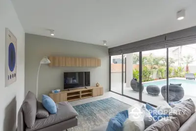 Modern living room with pool view, stylish decor, and natural light