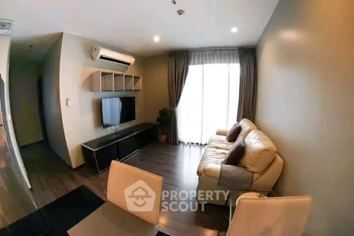 Modern living room with cozy sofa, wall-mounted TV, and elegant curtains in a stylish apartment.