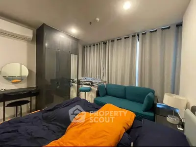 Modern bedroom with stylish furniture and cozy ambiance, featuring a vibrant orange bedspread and sleek decor.