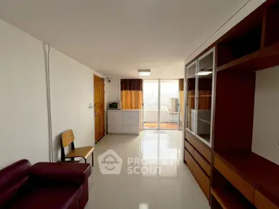 Spacious living room with modern furniture and balcony access in urban apartment.