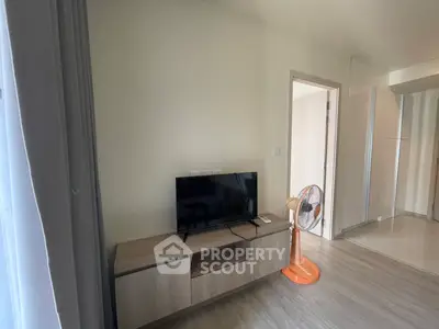 Modern living room with TV and wooden cabinet, featuring a sleek fan and minimalist decor.