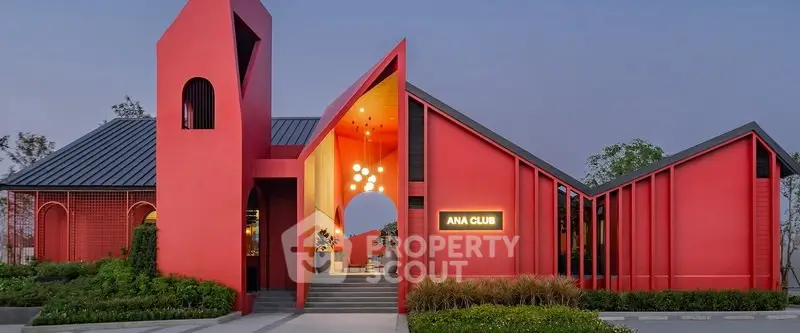 Stunning modern red building with unique architecture and inviting entrance, perfect for upscale real estate projects.