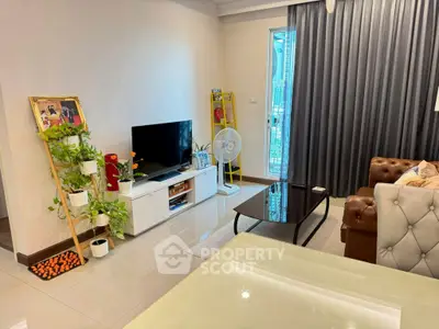 Stylish living room with modern decor, featuring a cozy sofa, TV unit, and vibrant plants.
