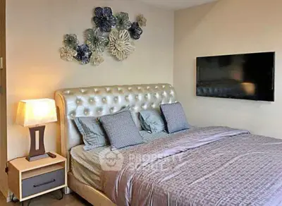 Luxurious bedroom with elegant decor and modern wall-mounted TV, perfect for relaxation.