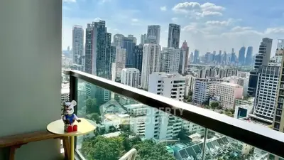 Stunning cityscape view from a modern balcony with glass railing, perfect for urban living.