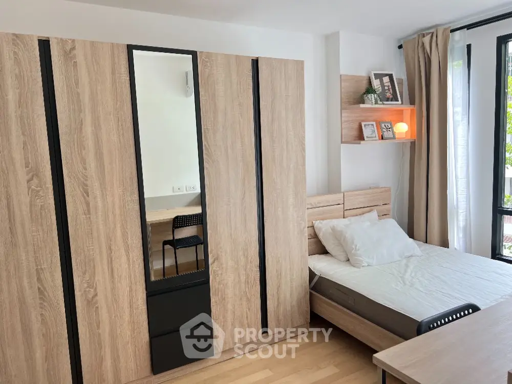 Modern bedroom with sleek wooden wardrobe and cozy bed, perfect for urban living.