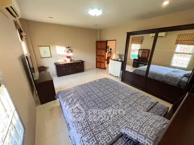 Spacious bedroom with mirrored wardrobe and elegant decor