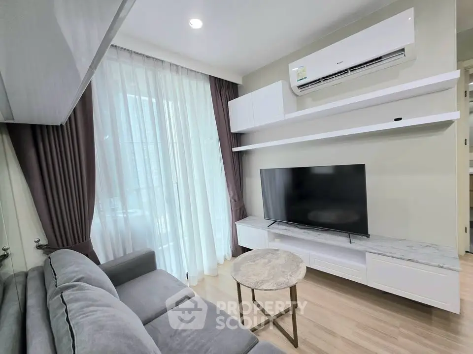 Modern living room with sleek furniture and large TV, featuring elegant curtains and air conditioning.