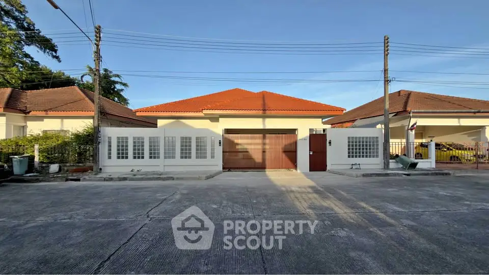 Charming single-story house with red-tiled roof and spacious driveway in a serene neighborhood.