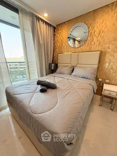 Luxurious bedroom with elegant decor and large window offering natural light.
